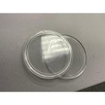 Close view of the two acrylic capsule halves separated, showing the rim that seats the coin
